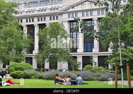 LONDON, Regno Unito - 9 Luglio 2016: le persone godono di estate in Bloomsbury Square Garden di Londra. L'edificio in background è il musei, biblioteche e archivi Foto Stock