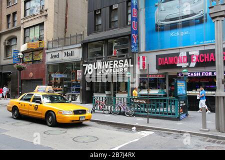 NEW YORK, USA - 4 LUGLIO 2013: Taxi guida nel quartiere Diamond lungo la 6th Avenue a New York. Quest'area è uno dei principali centri mondiali dell'industria dei diamanti Foto Stock
