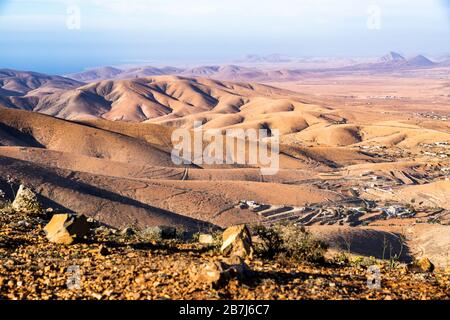 La vista su un paesaggio arido e arido da Mirador de Guise y Ayose nel centro dell'isola delle Canarie di Fuerteventura Foto Stock