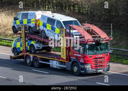 Ex Police furgoni commerciali, concessionario di pulmino di polizia, Motorhog, smontagomme e demolitori di veicoli specializzati, ritiro e consegne, Ford Transit 2.2 TDI furgoni, aste di auto ex-polizia; veicoli trasportati da SCANIA veicolo vettore sulla m61 autostrada, Regno Unito Foto Stock