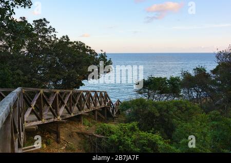 Un vecchio ponte in legno conduce fino alla costa del mare. Crepuscolo Foto Stock