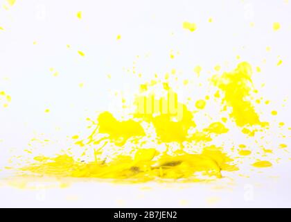 Vernice gialla splatter su sfondo bianco, piccolo campo di fuoco con elevata saturazione del colore. Foto Stock