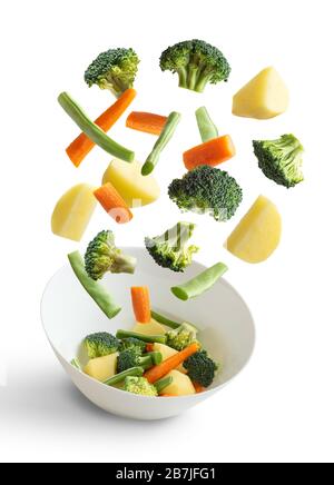 Verdure bollite che volano su sfondo bianco, fagiolo verde, broccoli, patate, carota Foto Stock