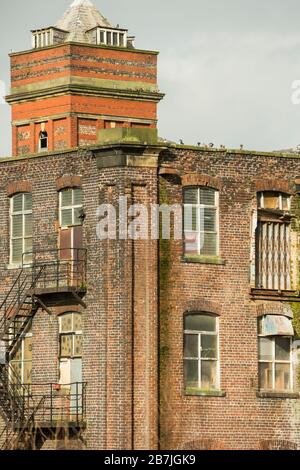 Derelict vecchio mulino di cotone con camini a Bury, Lancashire Inghilterra Foto Stock