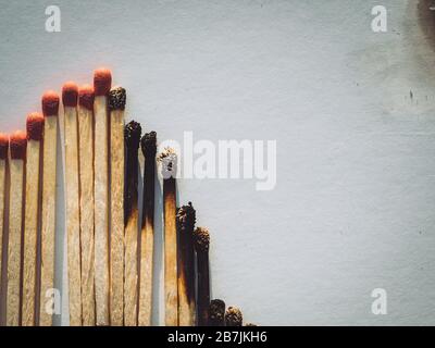 Fiammiferi bruciati. Concetto astratto di crollo del mercato azionario, giacitura piatta Foto Stock