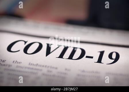 COVID-19 giornale scritto primo piano sul testo. Foto Stock