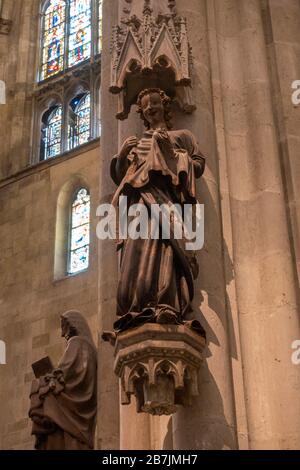 Una statua di "angelo mungente" all'interno del Duomo di San Pietro a Regensburg, Baviera, Germania. Foto Stock