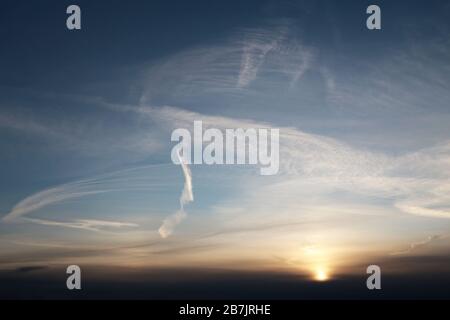 Tramonto sul cielo colorato con sole splendente. Pittoresco paesaggio nuvoloso con nuvole di cirri e colori tenui per lo sfondo Foto Stock