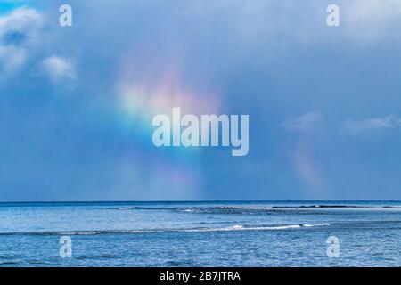 Splendida nuvola arcobaleno all'orizzonte nell'oceano vicino a Lahaina a Maui. Foto Stock