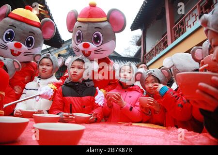 I bambini che indossano i copricapo del mouse si allineano per il porridge del riso per abbracciare il nuovo anno al Tempio di Xuanzang il giorno di Laba nella città di Nanjing, pr Jiangsu della Cina orientale Foto Stock