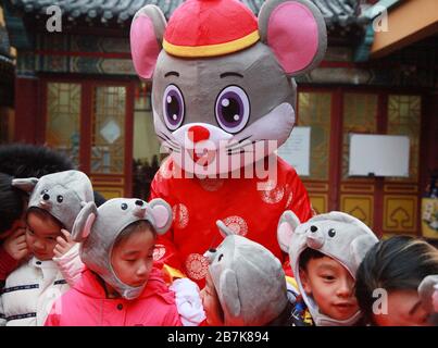 I bambini che indossano i copricapo del mouse si allineano per il porridge del riso per abbracciare il nuovo anno al Tempio di Xuanzang il giorno di Laba nella città di Nanjing, pr Jiangsu della Cina orientale Foto Stock