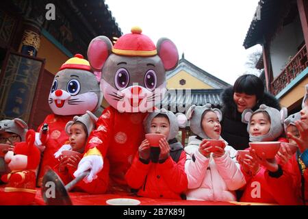 I bambini che indossano i copricapo del mouse si allineano per il porridge del riso per abbracciare il nuovo anno al Tempio di Xuanzang il giorno di Laba nella città di Nanjing, pr Jiangsu della Cina orientale Foto Stock