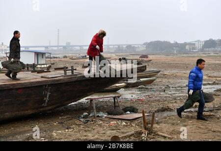 La gente sposta i bagagli da una barca da pesca vicino al lago Dongting nella città di Yueyang, nella provincia di Hunan della Cina centrale, il 30 dicembre 2019. Divieto di pesca di 10 anni t Foto Stock