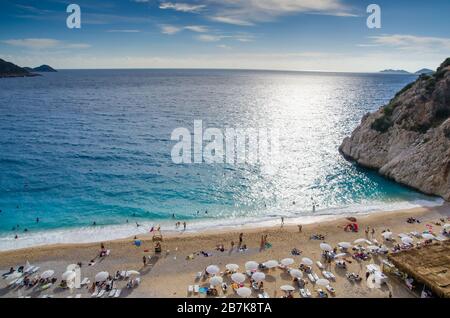 Antalya, Kas regione, Turchia - 28 settembre 2015: La famosa spiaggia di Kaputas. Persone che entrano nel mare e la spiaggia. Ombrelloni e lettini. Visualizza Foto Stock