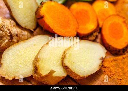 Radice di zenzero a fette (Zingiber officinale) e radice di curcuma (Curcuma longa). Foto Stock