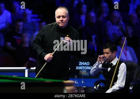 John Higgins di Scozia, a sinistra, considera un colpo a Zhao Xintong della Cina, a destra, al secondo round del World Grand Prix 2020 a Cheltenham, l'unità Foto Stock