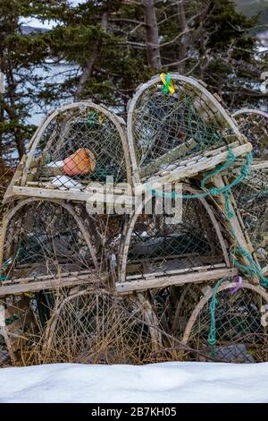 Le trappole di aragosta fatte di legno e maglia che sono immagazzinate nella bassa stagione vicino ad una piccola città in Terranova, Canada Foto Stock