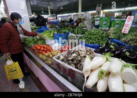 La gente acquista verdure in una bancarella di verdure in un mercato alimentare nella città di Nanjing, nella provincia di Jiangsu, nella Cina orientale, il 10 febbraio 2020. Foto Stock