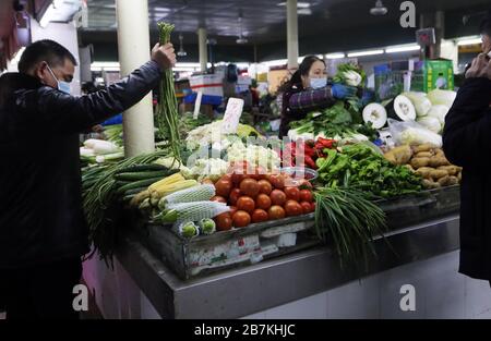 La gente acquista verdure in una bancarella di verdure in un mercato alimentare nella città di Nanjing, nella provincia di Jiangsu, nella Cina orientale, il 10 febbraio 2020. Foto Stock