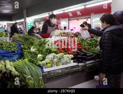 La gente acquista verdure in una bancarella di verdure in un mercato alimentare nella città di Nanjing, nella provincia di Jiangsu, nella Cina orientale, il 10 febbraio 2020. Foto Stock