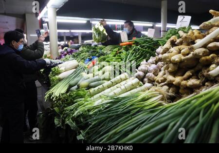 La gente acquista verdure in una bancarella di verdure in un mercato alimentare nella città di Nanjing, nella provincia di Jiangsu, nella Cina orientale, il 10 febbraio 2020. Foto Stock