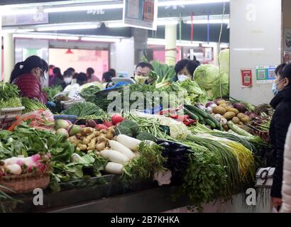 La gente acquista verdure in una bancarella di verdure in un mercato alimentare nella città di Nanjing, nella provincia di Jiangsu, nella Cina orientale, il 10 febbraio 2020. Foto Stock