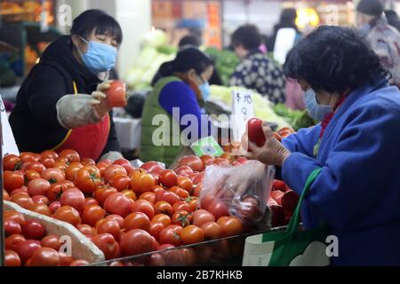 La gente acquista verdure in una bancarella di verdure in un mercato alimentare nella città di Nanjing, nella provincia di Jiangsu, nella Cina orientale, il 10 febbraio 2020. Foto Stock