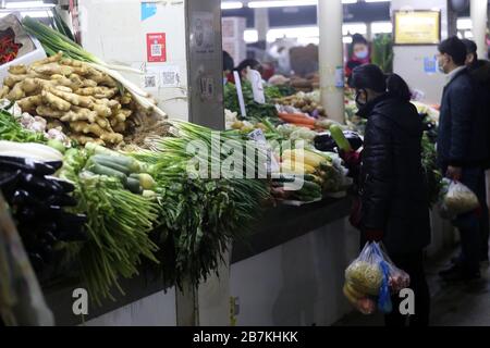 La gente acquista verdure in una bancarella di verdure in un mercato alimentare nella città di Nanjing, nella provincia di Jiangsu, nella Cina orientale, il 10 febbraio 2020. Foto Stock