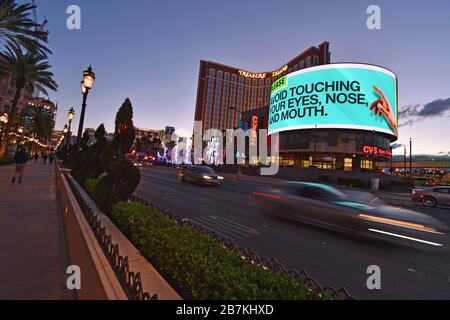 Las Vegas, Nevada, Stati Uniti. 16 Marzo 2020. Un annuncio di servizio pubblico dai Centri per il controllo e la prevenzione delle malattie è esposto promuovendo 'evitare di toccare i vostri occhi, naso e bocca.' lungo la Strip di Las Vegas il 16 marzo 2020 a Las Vegas, Nevada. Con lo scoppio del coronavirus (COVID-19) molti degli hotel-casinò lungo il famoso viale sono in programma di chiudere. Credit: David Becker/ZUMA Wire/Alamy Live News Foto Stock