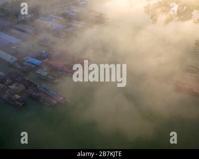 Una vista aerea delle barche e delle navi che si trovano in un molo e coperte di nebbia nel lago di Hongze, la città di Huai'an, provincia di Jiangsu della Cina orientale, 12 febbraio 20 Foto Stock