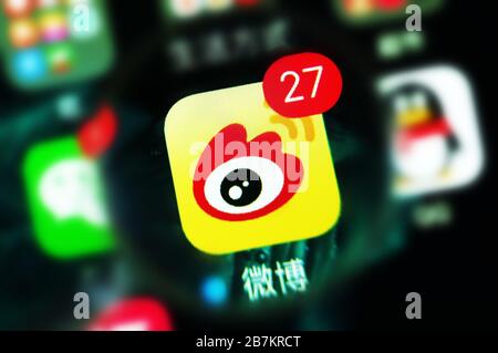 Foto creativa: Il logo di Sina Weibo, un sito web cinese di microblogging (weibo) simile a Twitter, è mostrato su uno smartphone come il proprietario lo sta utilizzando, Foto Stock