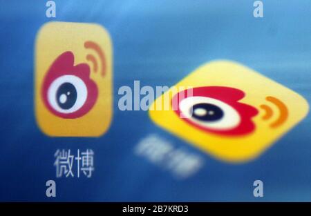 Foto creativa: Il logo di Sina Weibo, un sito web cinese di microblogging (weibo) simile a Twitter, è mostrato su uno smartphone come il proprietario lo sta utilizzando, Foto Stock