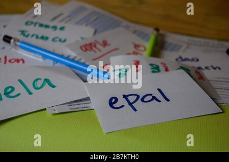 EPAL scrivere su una nota appiccicosa la sua mela media isolato su Office Desk. Apprendimento del concetto di lingua malese Foto Stock