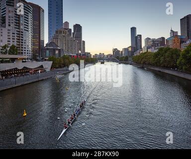 Vogatori sul fiume Yarra nel CBD di Melbourne al crepuscolo Foto Stock