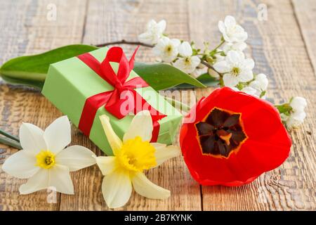 Fiori di tulipano, naffodils e gelsomino con scatola regalo su vecchie tavole di legno. Foto Stock