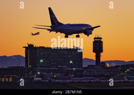 Richmond, British Columbia, Canada. 16 Marzo 2020. Lunedì 16 marzo 2020 atterra un jet WestJet Airlines Boeing 737-600 (C-GWCQ) al tramonto, all'aeroporto internazionale di Vancouver, a Richmond, B.C., Canada. All'inizio del giorno il governo canadese, nel tentativo di fermare la diffusione del romanzo coronavirus, ha annunciato che i confini della nazione sarebbero stati chiusi a partire da mercoledì 18 marzo a tutti i viaggiatori diversi dai cittadini canadesi e residenti permanenti, cittadini statunitensi, diplomatici e lavoratori essenziali. Credit: Bayne Stanley/ZUMA Wire/Alamy Live News Foto Stock