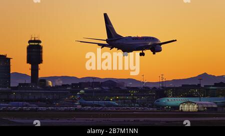 Richmond, British Columbia, Canada. 16 Marzo 2020. Lunedì 16 marzo 2020 atterra un jet WestJet Airlines Boeing 737-600 (C-GWCQ) al tramonto, all'aeroporto internazionale di Vancouver, a Richmond, B.C., Canada. All'inizio del giorno il governo canadese, nel tentativo di fermare la diffusione del romanzo coronavirus, ha annunciato che i confini della nazione sarebbero stati chiusi a partire da mercoledì 18 marzo a tutti i viaggiatori diversi dai cittadini canadesi e residenti permanenti, cittadini statunitensi, diplomatici e lavoratori essenziali. Credit: Bayne Stanley/ZUMA Wire/Alamy Live News Foto Stock