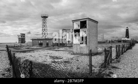 Dungeness è un promontorio del deserto sulla costa del Kent in Inghilterra. Un cottage sulla spiaggia e il vecchio faro. Foto Stock