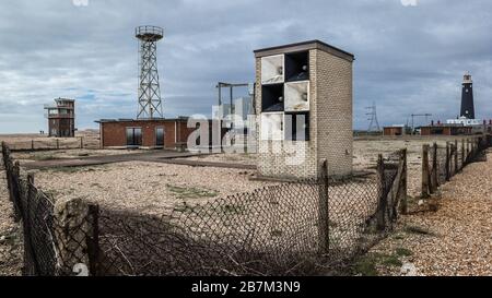 Dungeness è un promontorio del deserto sulla costa del Kent in Inghilterra. Un cottage sulla spiaggia e il vecchio faro. Foto Stock