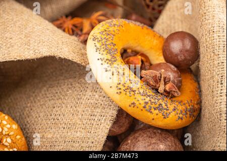 Cioccolato, bagel e pan di zenzero al cioccolato su uno sfondo di tessuto grezzo. Primo piano Foto Stock