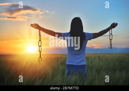 Donna sentendosi libera in un bellissimo ambiente naturale, in quale campo al tramonto. Senza catene Foto Stock