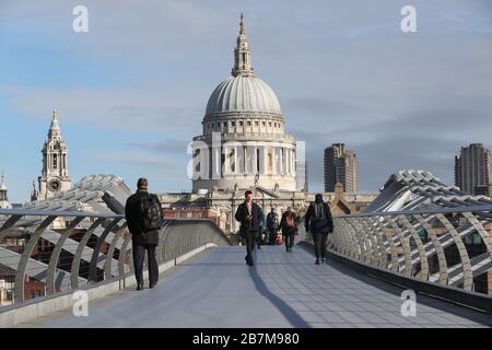 I pendolari attraversano un Millennium Bridge quasi vuoto a Londra, il giorno dopo che il primo ministro Boris Johnson ha invitato le persone a stare lontano da pub, club e teatri, lavorare da casa se possibile ed evitare tutti i contatti non essenziali e viaggiare per ridurre l'impatto della pandemia di coronavirus. Foto Stock