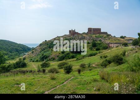 Hammershus, Bornholm / Danimarca - Luglio 29 2019: Colline erbose infornt di vecchia fortificazione sull'isola di Dansigh di Bornholm con le rovine sulla cima di un Foto Stock