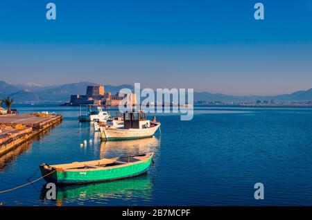 Lo storico castello d'acqua di Bourtzi sullo sfondo e legno di piccole barche da pesca sul primo piano. Foto Stock