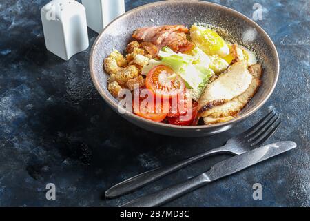 Caesar insalata di pomodori di pollo alla griglia, lattuga, cracker e uova. Dieta sana. Su sfondo scuro. Spazio di copia. Foto Stock