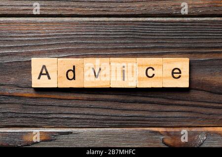 Parola di consiglio scritta su blocco di legno. Testo di consiglio sul tavolo di legno per il vostro desing, concetto di vista dall'alto. Foto Stock