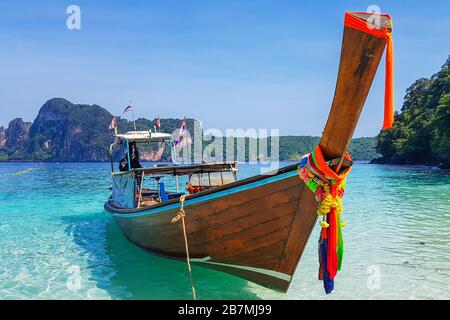 Barca a coda lunga sulla spiaggia delle scimmie a Koh Phi Phi Foto Stock