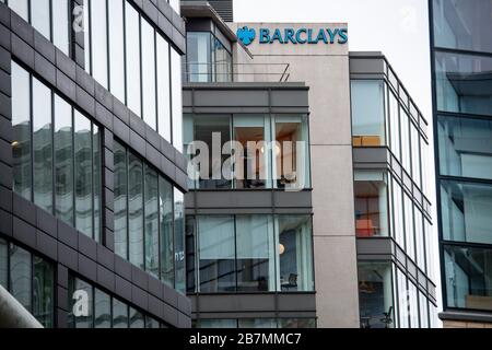 Un uomo guarda fuori dalla finestra di un ufficio di Barclays a Manchester, il giorno dopo che il primo ministro Boris Johnson ha invitato le persone a stare lontano da pub, club e teatri, lavorare da casa se possibile ed evitare tutti i contatti non essenziali e viaggiare per ridurre l'impatto della pandemia di coronavirus. Foto Stock