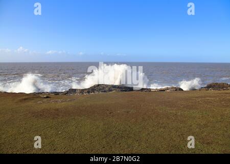 Grandi onde che si infrangono nelle scogliere a Ogmore via mare a Bridgend con un'alta marea dopo tempeste che ha fatto le onde. Foto Stock