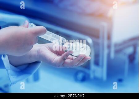 Il medico sta usando una siringa con il vaccino per trattare il malato covid19 Foto Stock